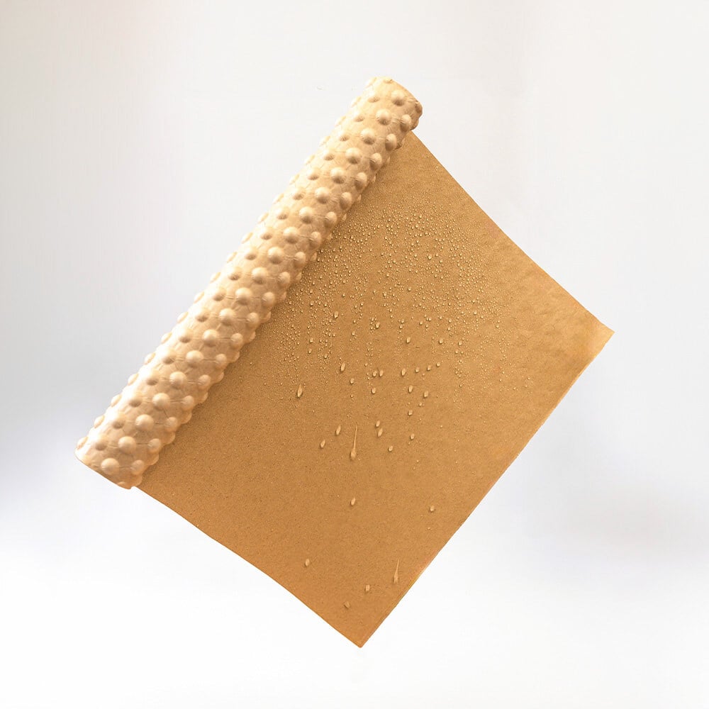 Beschichtetes PapairWrap Plus halb eingerollt mit vielen kleinen Wassertropfen darauf, die abperlen.